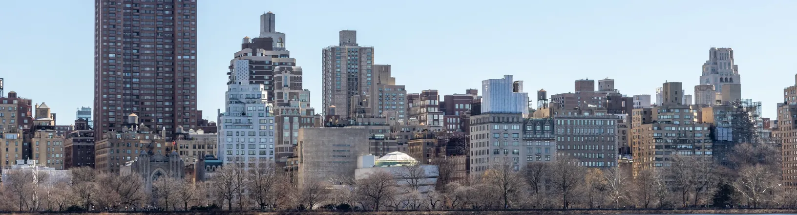 Lower Manhattan seen across the water on a clear day, with the Brooklyn Bridge and the downtown skyline.