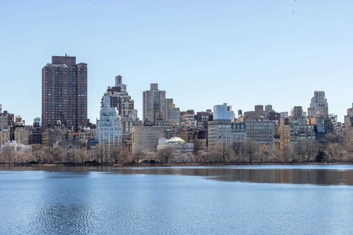 Lower Manhattan seen across the water on a clear day, with the Brooklyn Bridge and the downtown skyline.