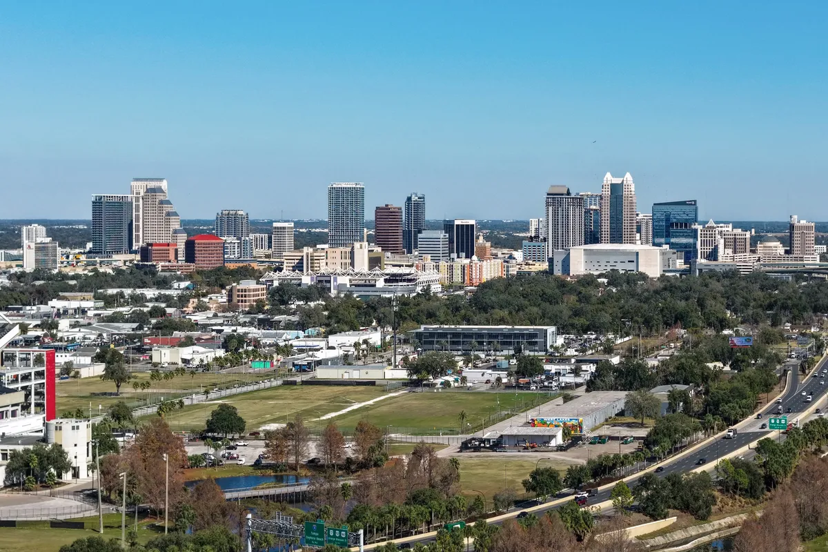 The downtown Orlando skyline on a clear day, with office towers behind low-rise neighbourhoods.